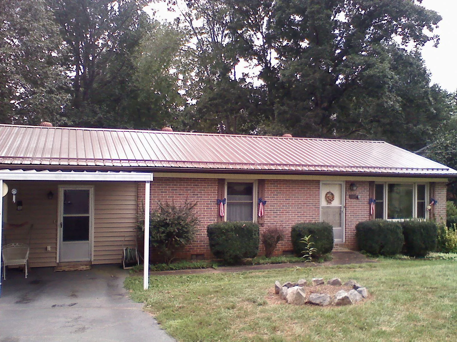 Bronze metal roof and carport on a brick ranch home — Roof Repair work by our crew in La Porte